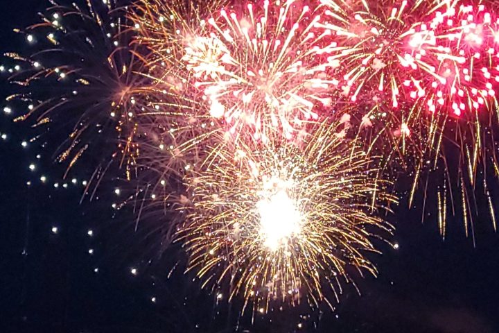 Red fireworks at night as seen during a harbor fireworks display