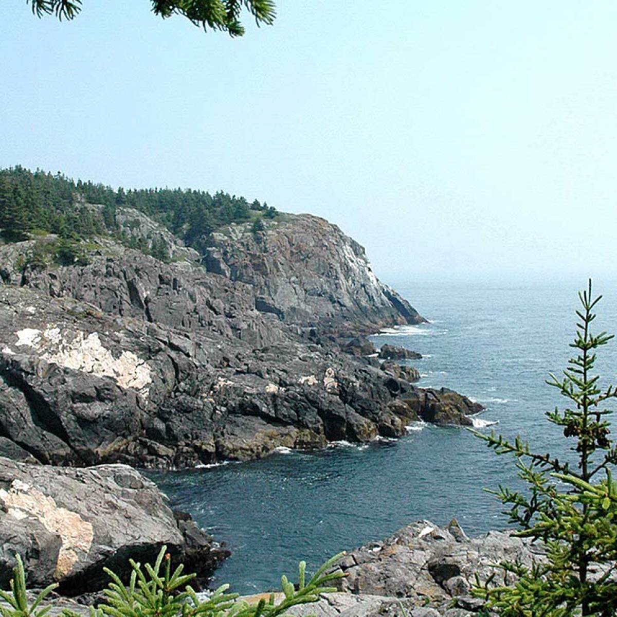 a rocky cliffside up against the ocean shore